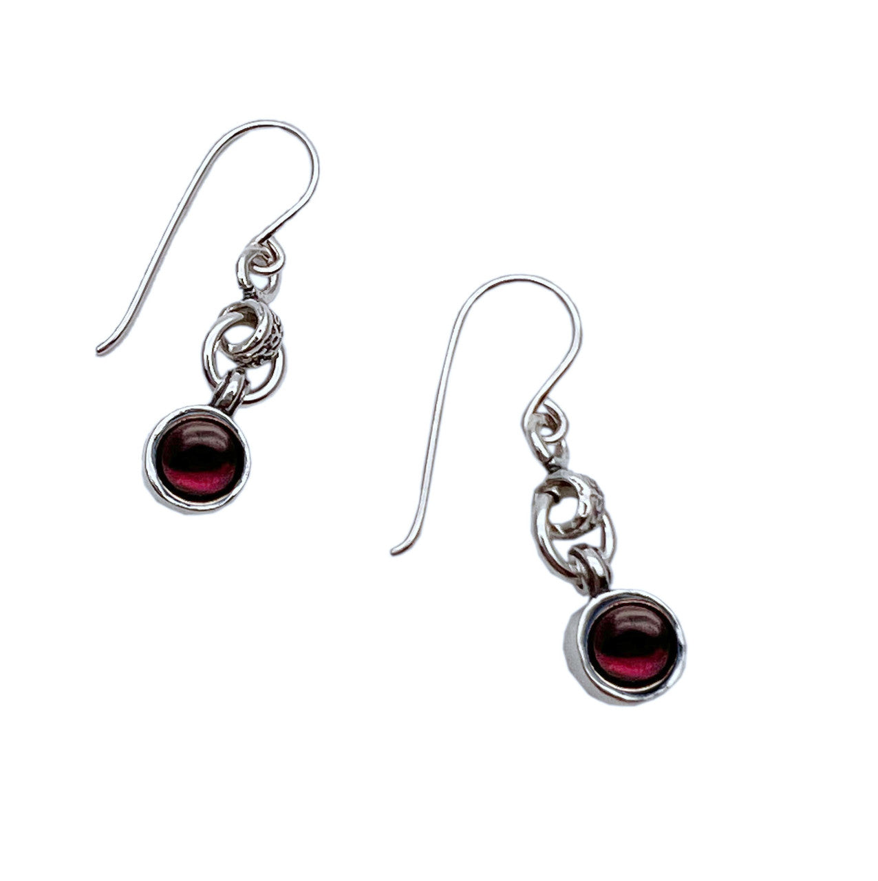 Delicate sterling silver hook earrings featuring lustrous round garnet stones that catch light with a deep, wine-red brilliance