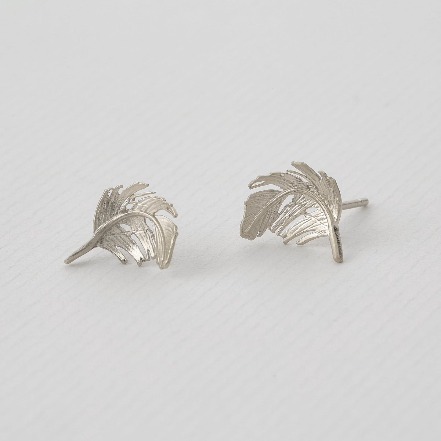 Sterling Silver Feather Stud Earrings on a grey background