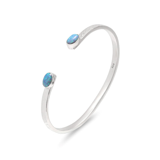Silver bangle with blue opal stones on a white background