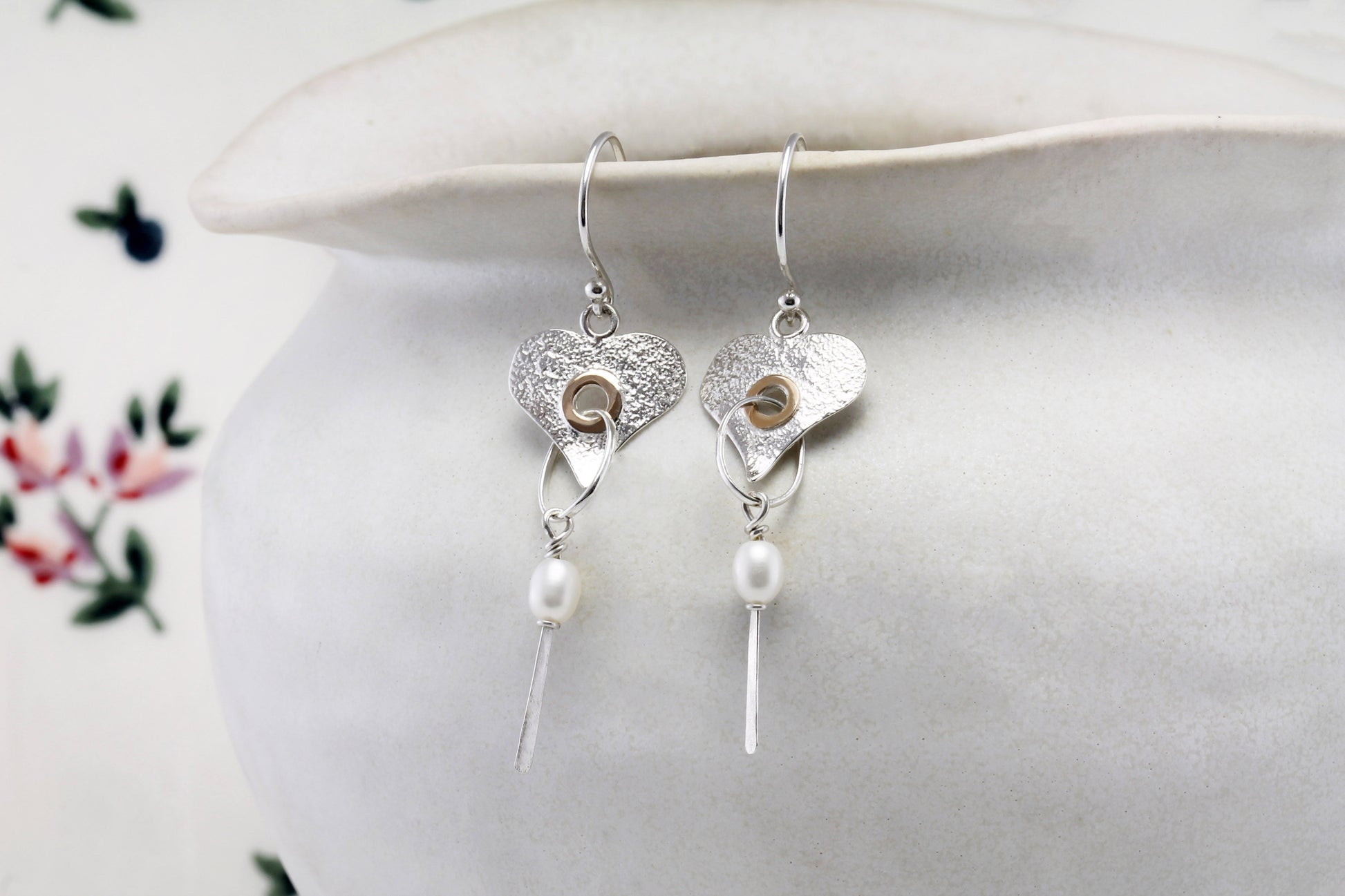 Sterling Silver Handmade Pearl Heart Drop Earring With 18 carat Vermeil Detail hanging from a pot