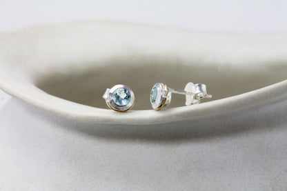 Pair of Sterling Silver Topaz With Gold Detail Studs on a white dish