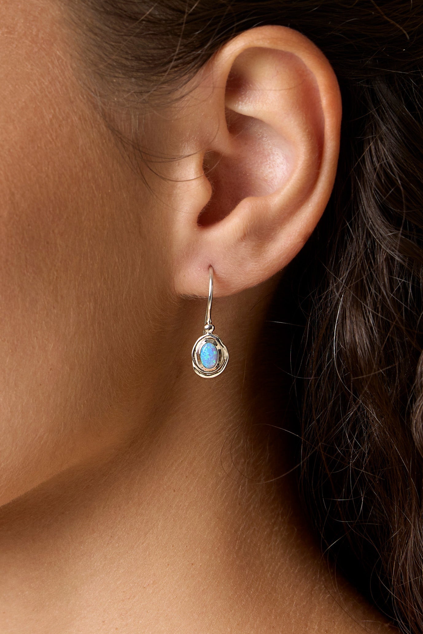 Close-up of an ear wearing a Sterling Silver Handmade Dainty Opalite Hook Earring