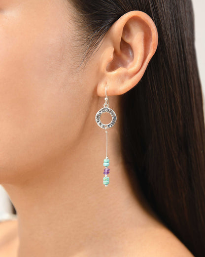 Close-up of an ear wearing a Hammered Circle Drop Earrings Turquoise & Amethyst Drop Earring