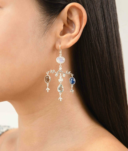Close-up of a woman wearing a Sterling Silver Chandelier Gemstone Statement Earrings earring with gemstones against a neutral background