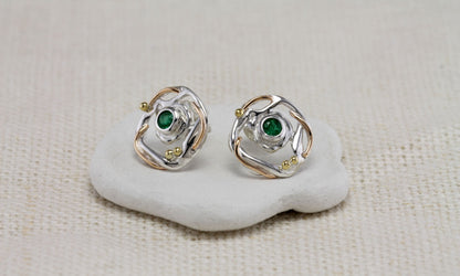 Sterling Silver Circular Mixed Metal Round Emerald Stud Earrings on a white stone