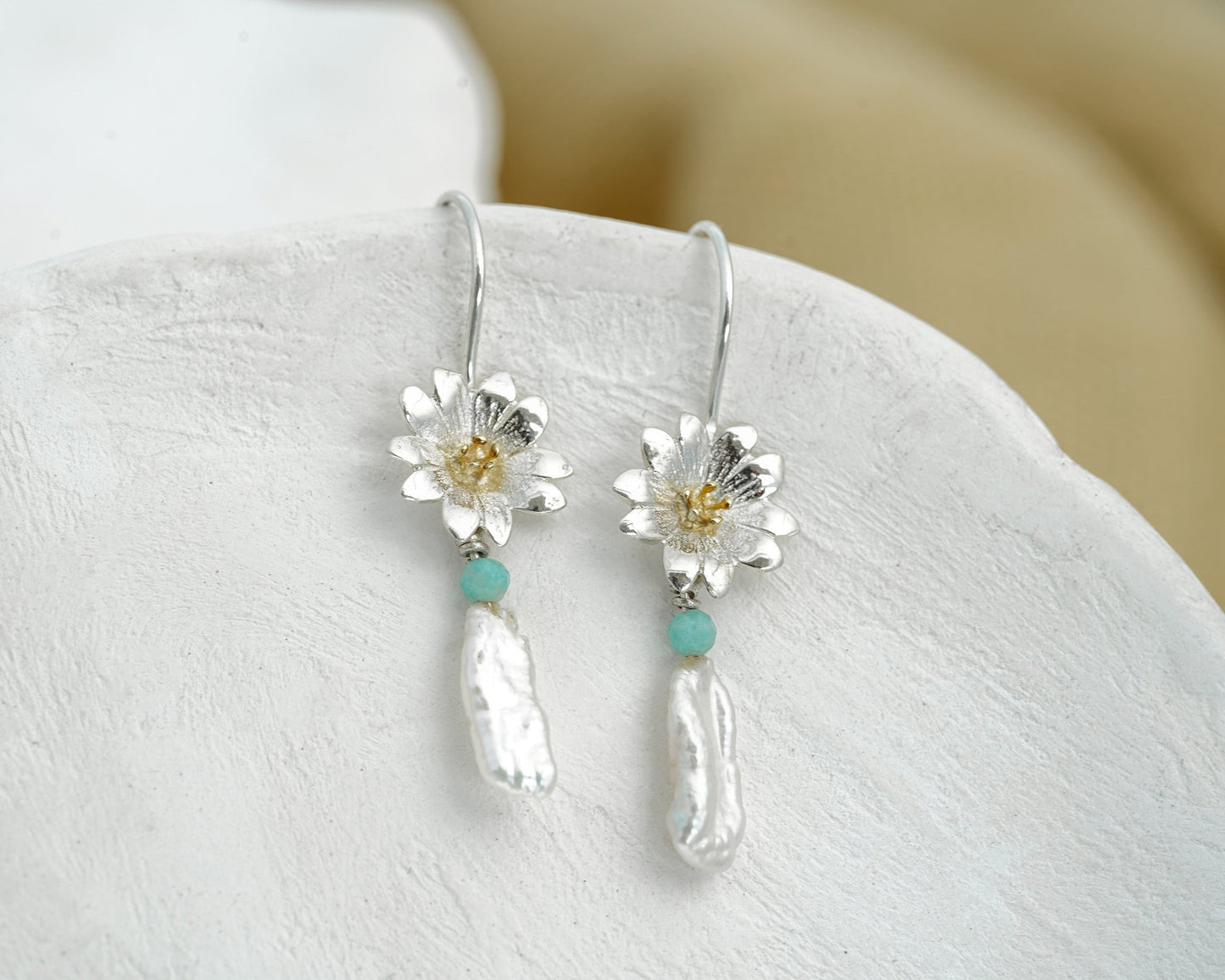 Sterling Silver Daisy Baroque Pearl & Aventurine Drop Earrings hanging on a stone surface