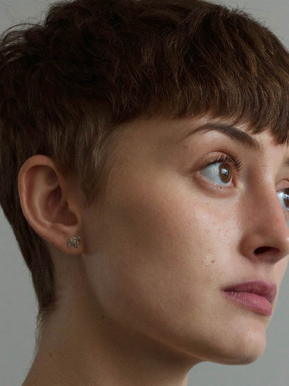 Close-up of a person wearing a Alex Monroe Silver & Gold Vermeil Marching Elephant Stud Earring