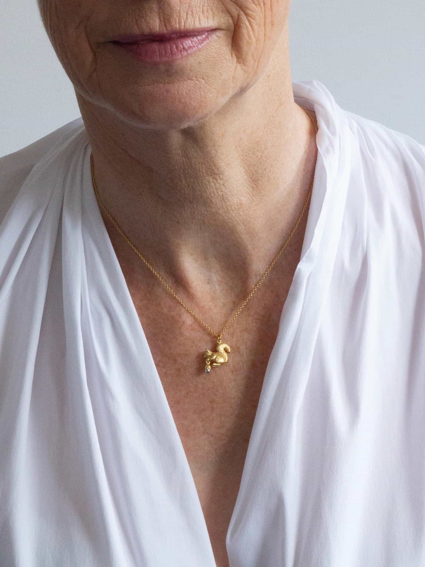 Alex Monroe 22 carat Gold Vermeil & Sterling Silver Squirrel & Acorn Necklace worn by a model
