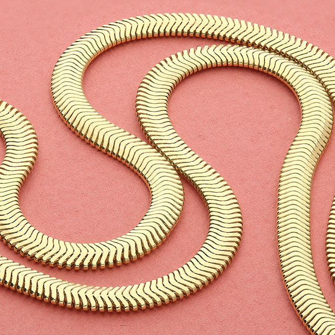Sterling Silver 14ct Gold Vermeil  Flat Oval Snake Chain Bracelet with a wavy pattern on a pink background