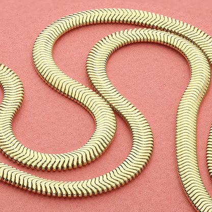 Sterling Silver 14ct Gold Vermeil  Flat Oval Snake Chain Bracelet with a wavy pattern on a pink background