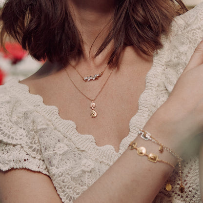 Close-up of a person wearing gold necklaces and bracelets with a blurred background